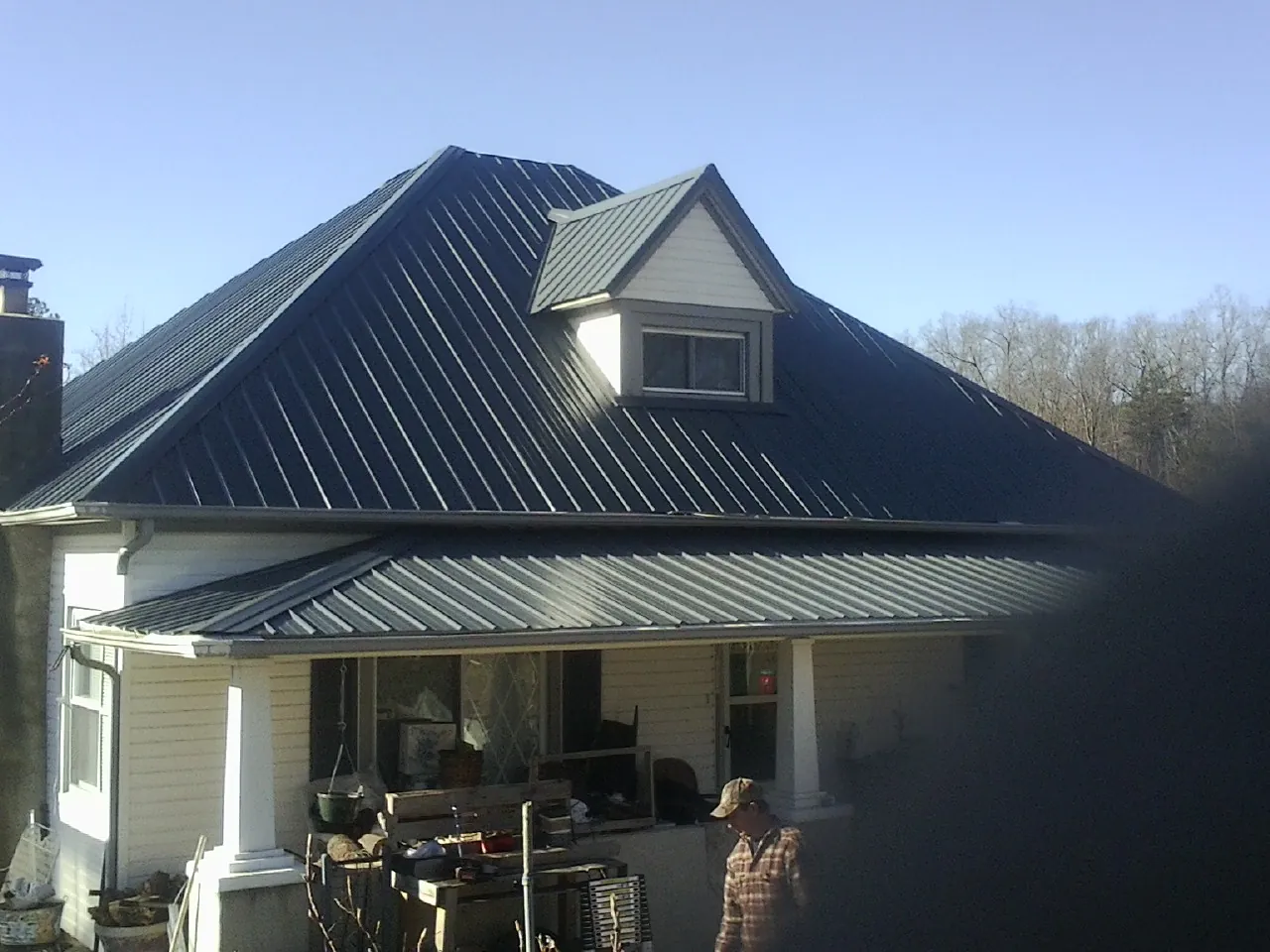 Dark blue standing seam metal roof with a dormer above a front porch in Heber City