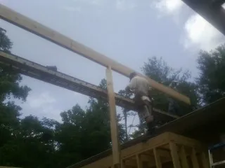 Carpenter setting a ridge beam over a new addition frame — Ice Dam Removal by Roofing Brothers in Heber City