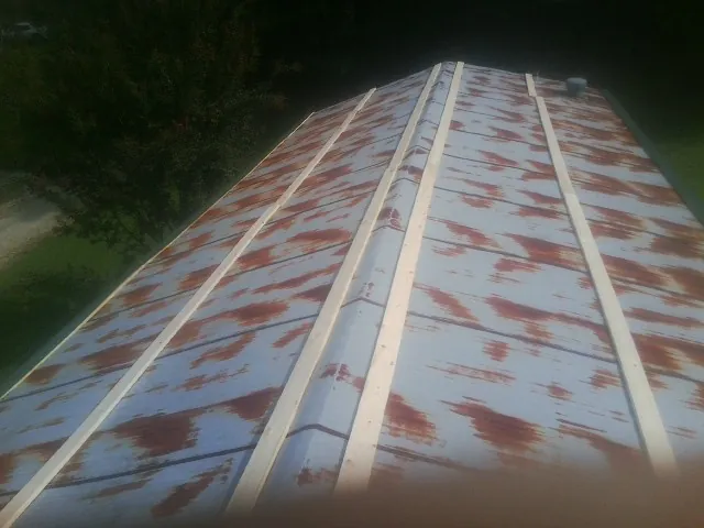 Rusted metal roof panels with new wood purlins before replacement — Storm Damage Roof Repair in Heber City by Roofing Brothers