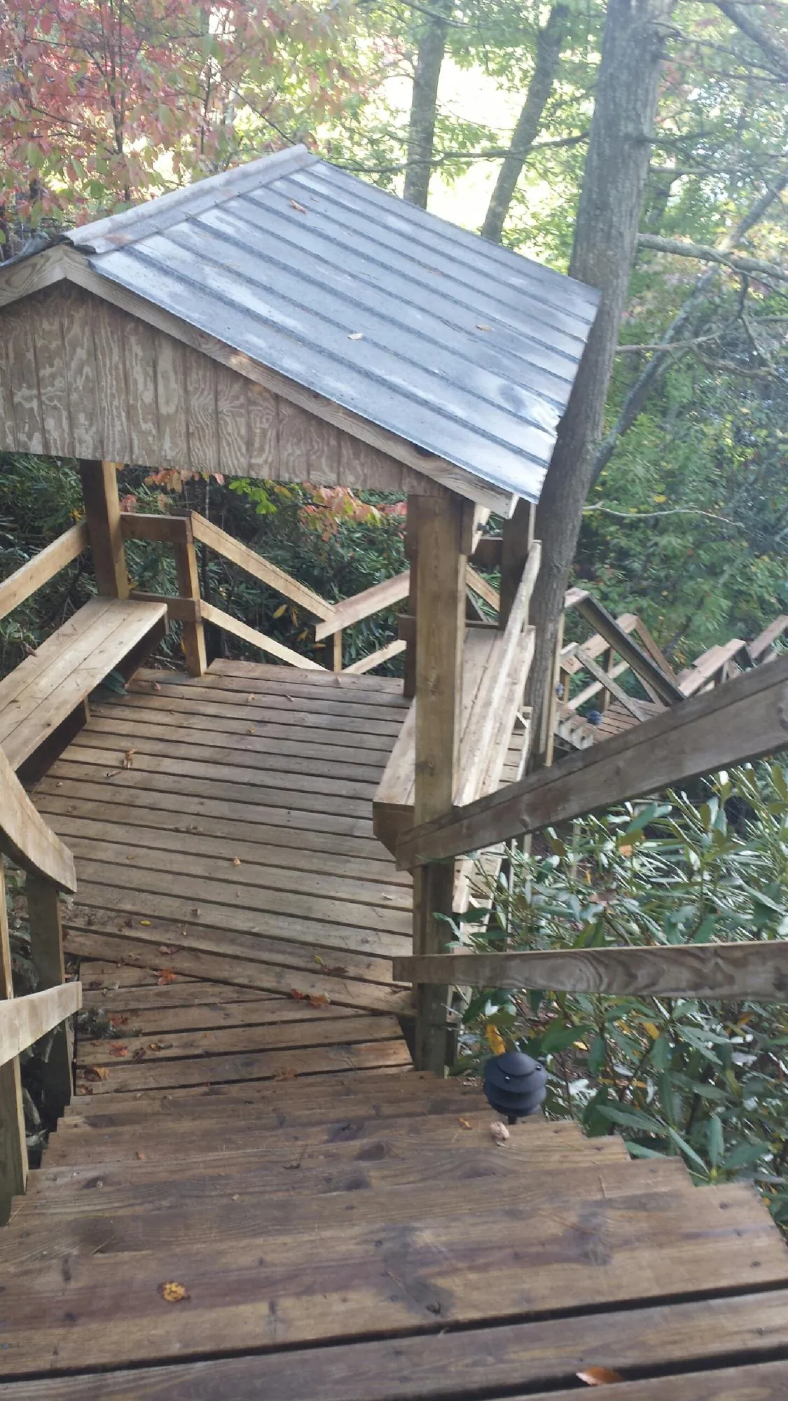 Metal roofed shelter over wooden steps on a wooded walkway — Skylight Repair & Installation work by our crew in Heber City